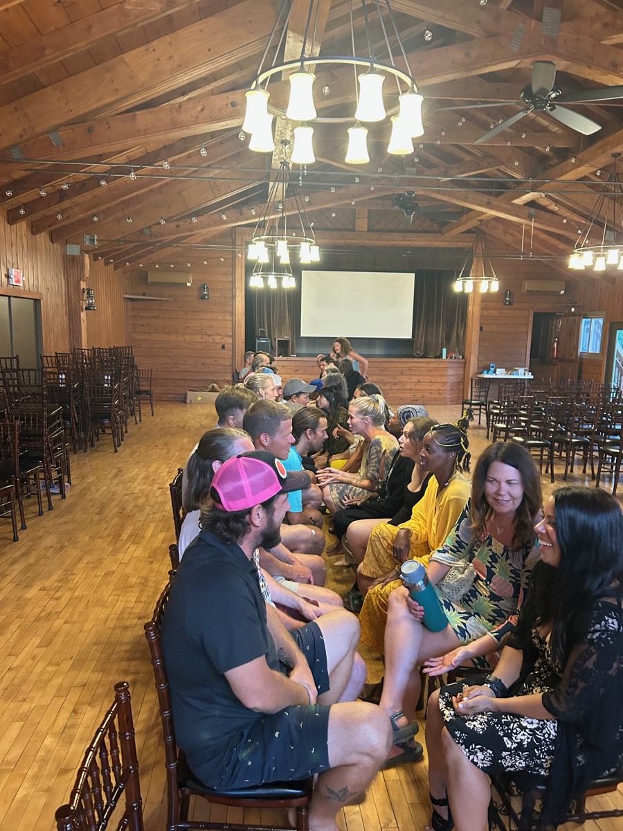 Retreat guests laughing together across the rows during the Speed Dating night